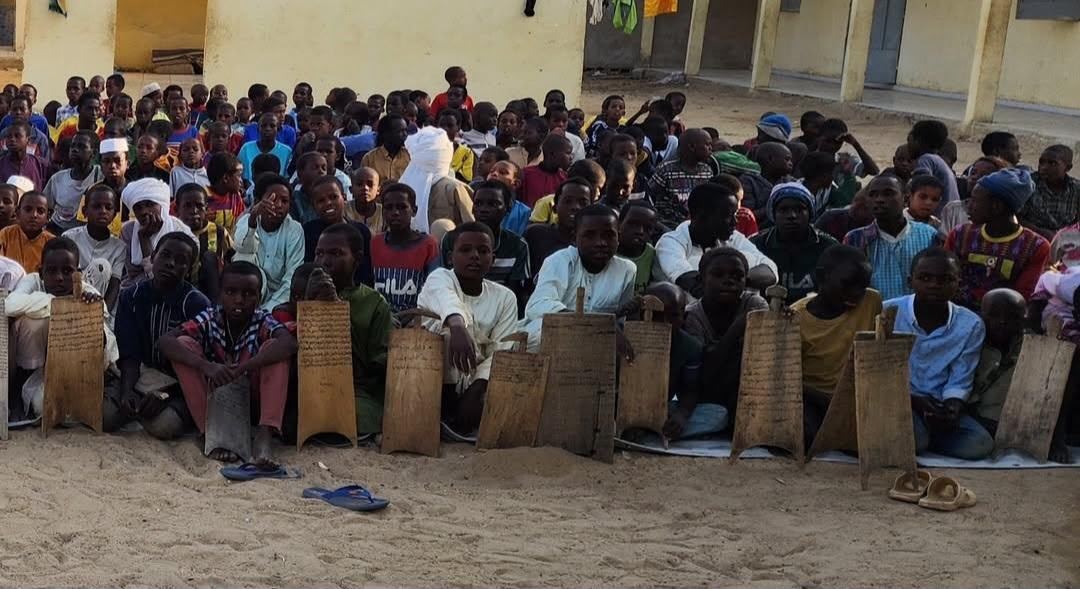 Enfants suivant un enseignement coranique en plein air